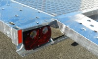 Trailer with alloy tread floor and steel ramp located to load